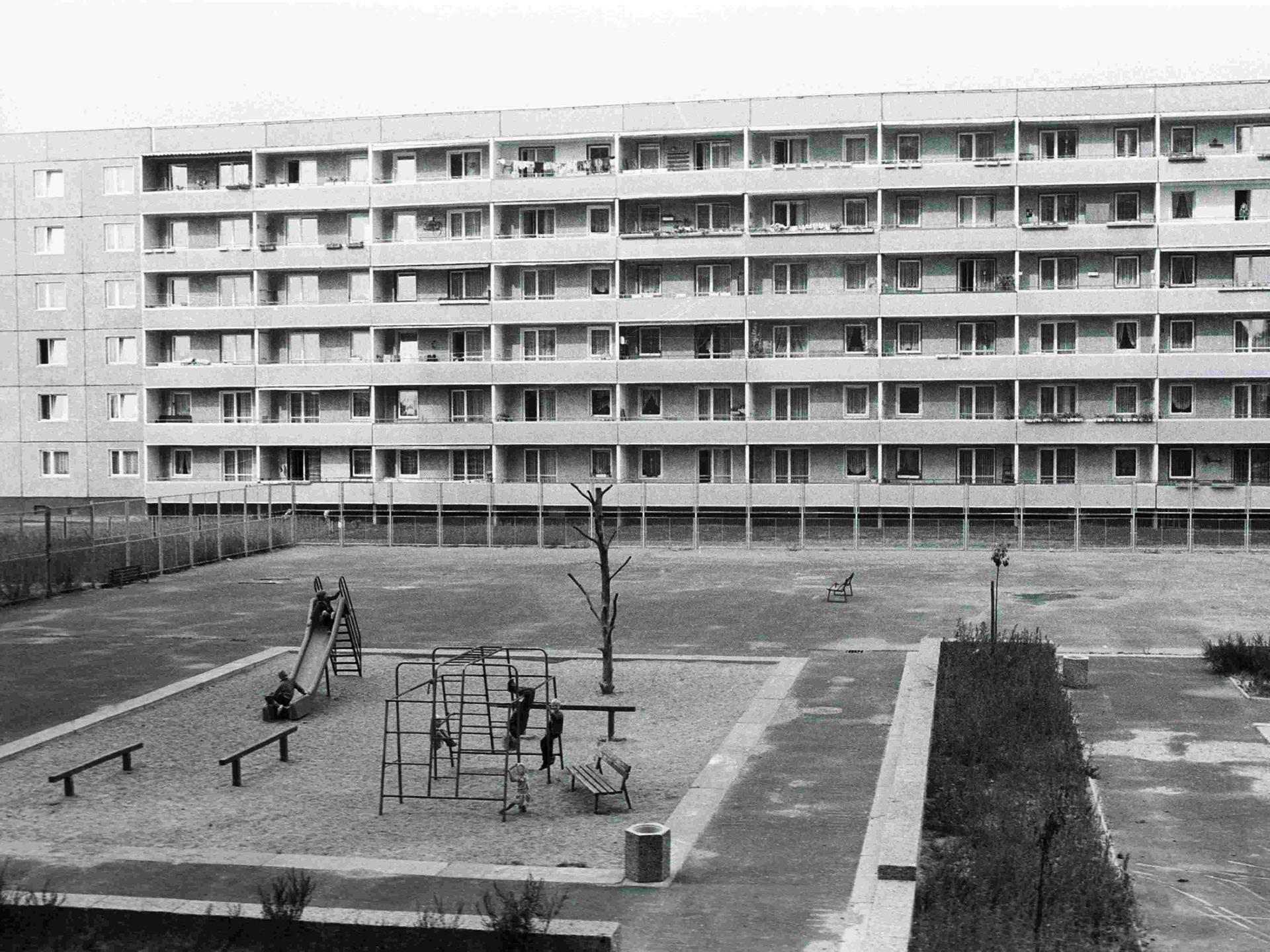 Schwarz-Weiß-Bild eines Spielplatzes aus der Vogelperspektive inmitten von Plattenbauten in der Joseph-Orlopp-Straße in Berlin-Lichtenberg zu DDR-Zeiten