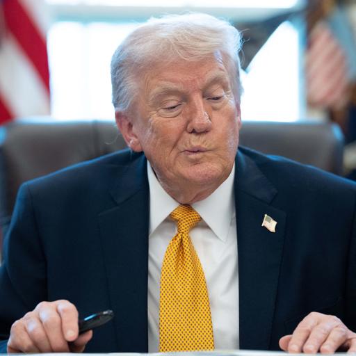 US-Präsident Trump sitzt im Oval Office im Weißen Haus an einem Schreibtisch und verzieht nachdenklich das Gesicht.