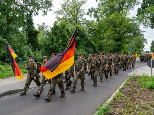 Soldaten der Bundeswehr marschieren auf einer Chaussee in Brandenburg
