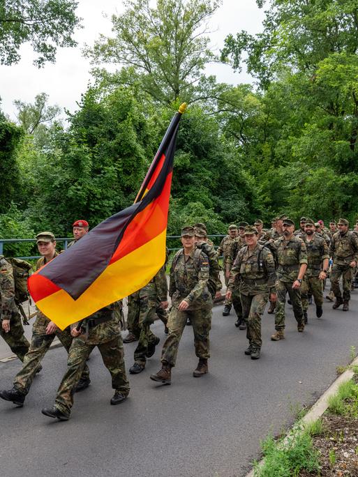 Soldaten der Bundeswehr marschieren auf einer Chaussee in Brandenburg