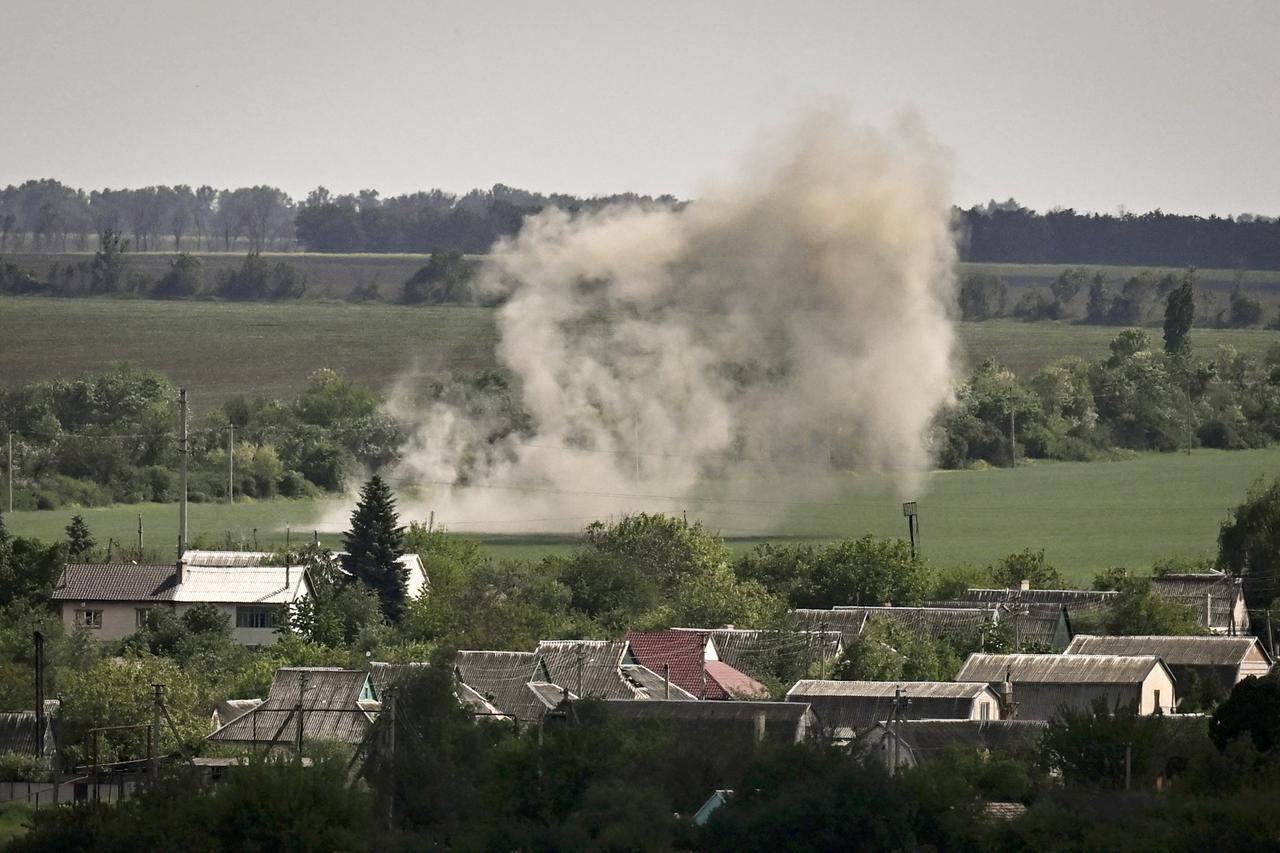 Staub steigt aus einem Feld hinter Häusern in Soledar in der Region Donezk auf. 