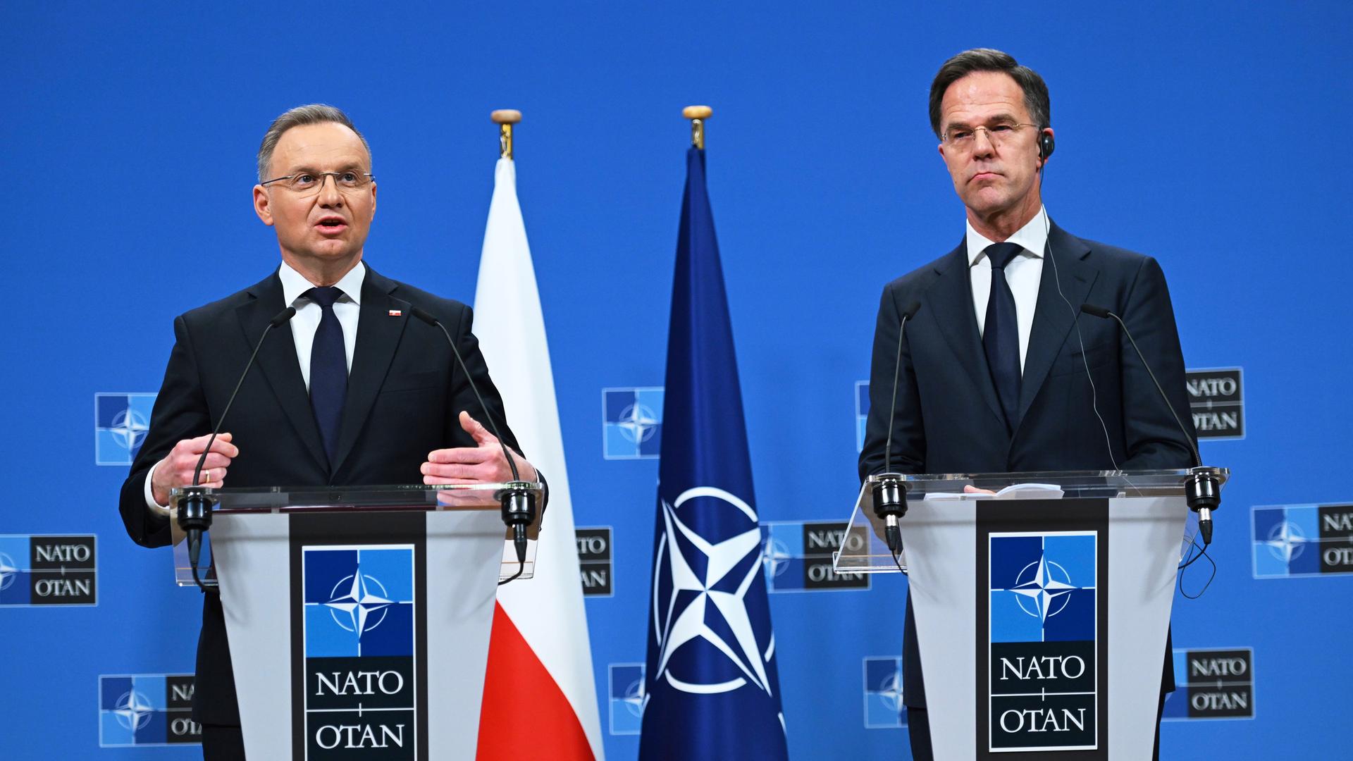 Polens Präsident Andrej Duda und NATO-Generalsekretär Mark Rutte stehen auf einer Pressekonferenz in Brüssel nebeneinander an Rednerpulten. 