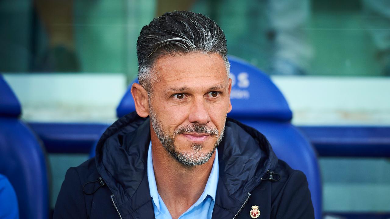 Trainer Martin Demichelis sitzt am Rand des Fußballplatzes. 