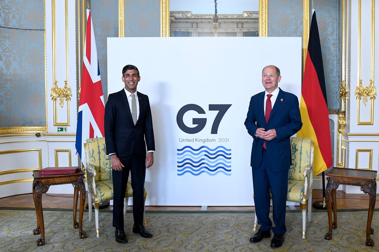 Rishi Sunak (l) hat als damaliger Finanzminister von Großbritannien den damaligen Bundesfinanzminister Olaf Scholz persönlich getroffen -  während eines Treffens der G7-Finanzminister. Beide stehen mit etwas Abstand in einem Raum und lächeln in die Kamera. 