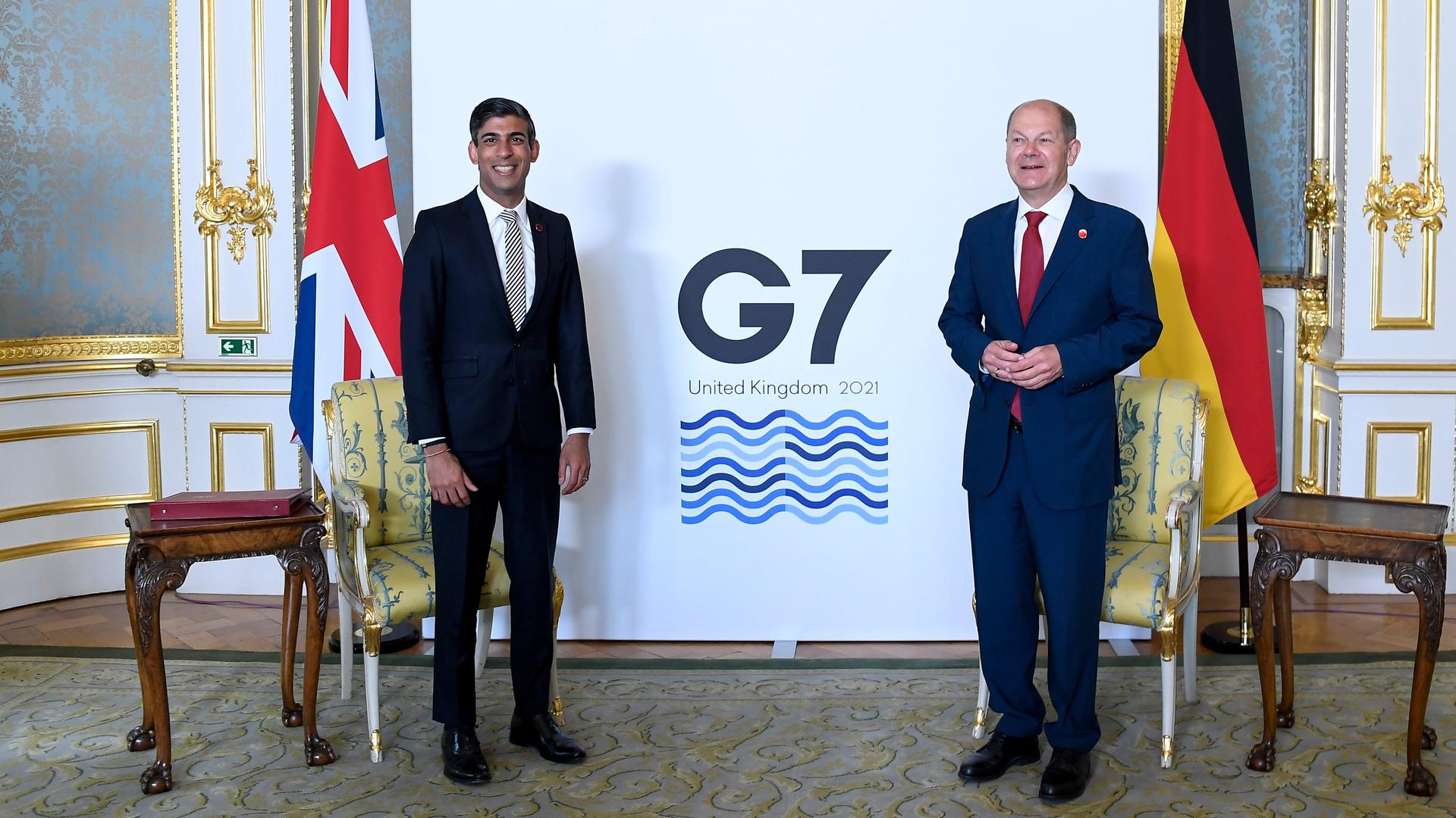 Rishi Sunak (l) hat als damaliger Finanzminister von Großbritannien den damaligen Bundesfinanzminister Olaf Scholz persönlich getroffen - während eines Treffens der G7-Finanzminister. Beide stehen mit etwas Abstand in einem Raum und lächeln in die Kamera.