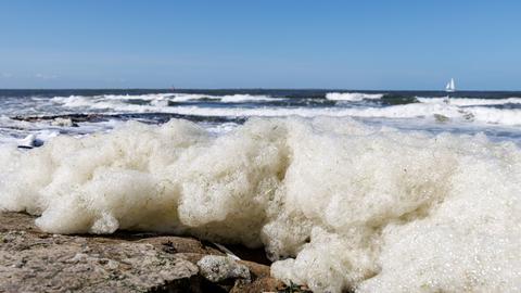 Wellen spülen Schaum an den Strand der ostfriesischen Insel Norderney Wellen spülen Schaum an den Strand der ostfriesischen Insel Norderney