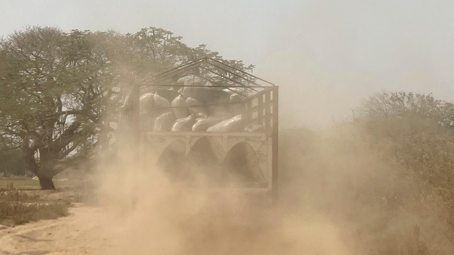 Ein Lastwagen mit Reissäcken beladen fährt im nigerianischen Bundesstaat Benue über eine staubige Sandstraße. Ein Lastwagen mit Reissäcken beladen fährt im nigerianischen Bundesstaat Benue über eine staubige Sandstraße.