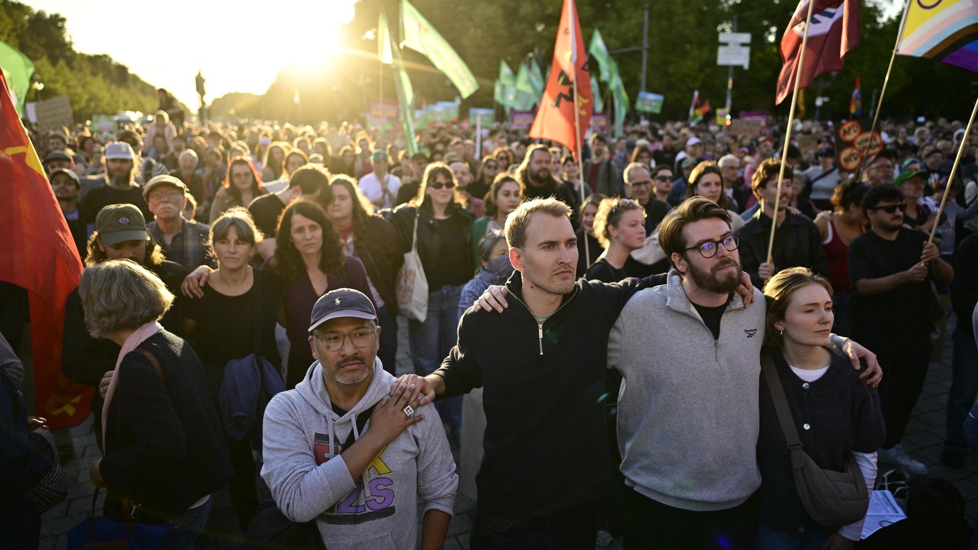 Menschen stehen mit Fahnen am Brandenburger Tor mit Blick auf die Siegessäule während einer Kundgebung gegen die AfD. Menschen stehen mit Fahnen am Brandenburger Tor mit Blick auf die Siegessäule während einer Kundgebung gegen die AfD.