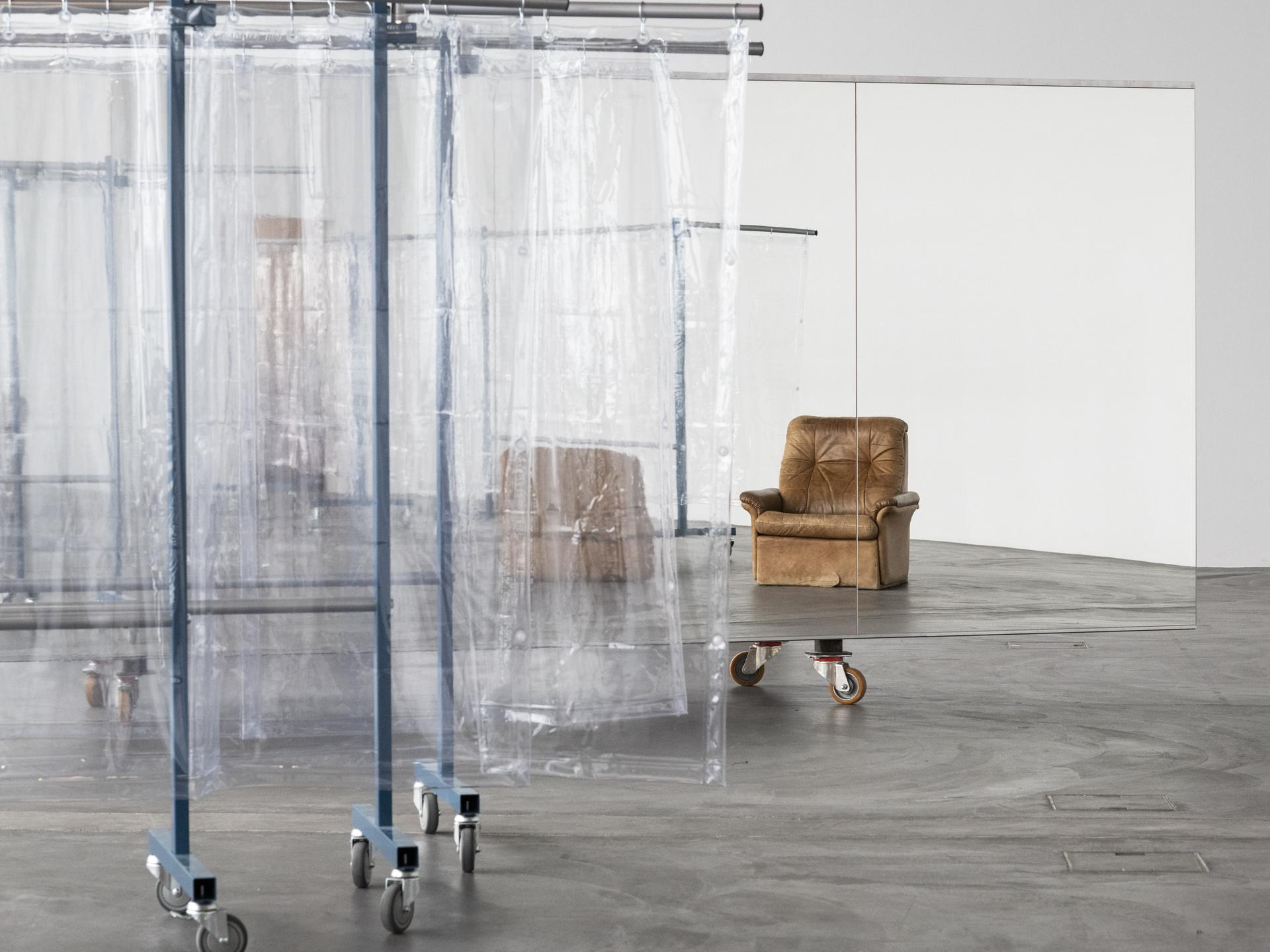 Blick in das experimentelle Live-Kunstwerk „Scalable Skeletal Escalator“ der in Berlin lebenden Künstlerin Isabel Lewis in der Kunsthalle Zürich, Schweiz. Sichtbar sind Folien als Raumtrenner und ein Sessel.