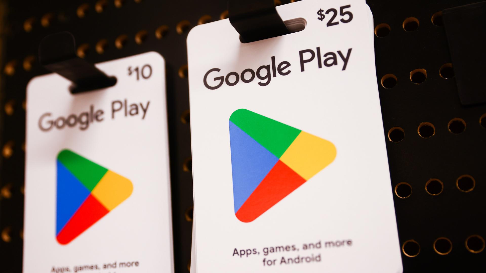 An zwei Haken hängen Guthabenkarten für Google Play.