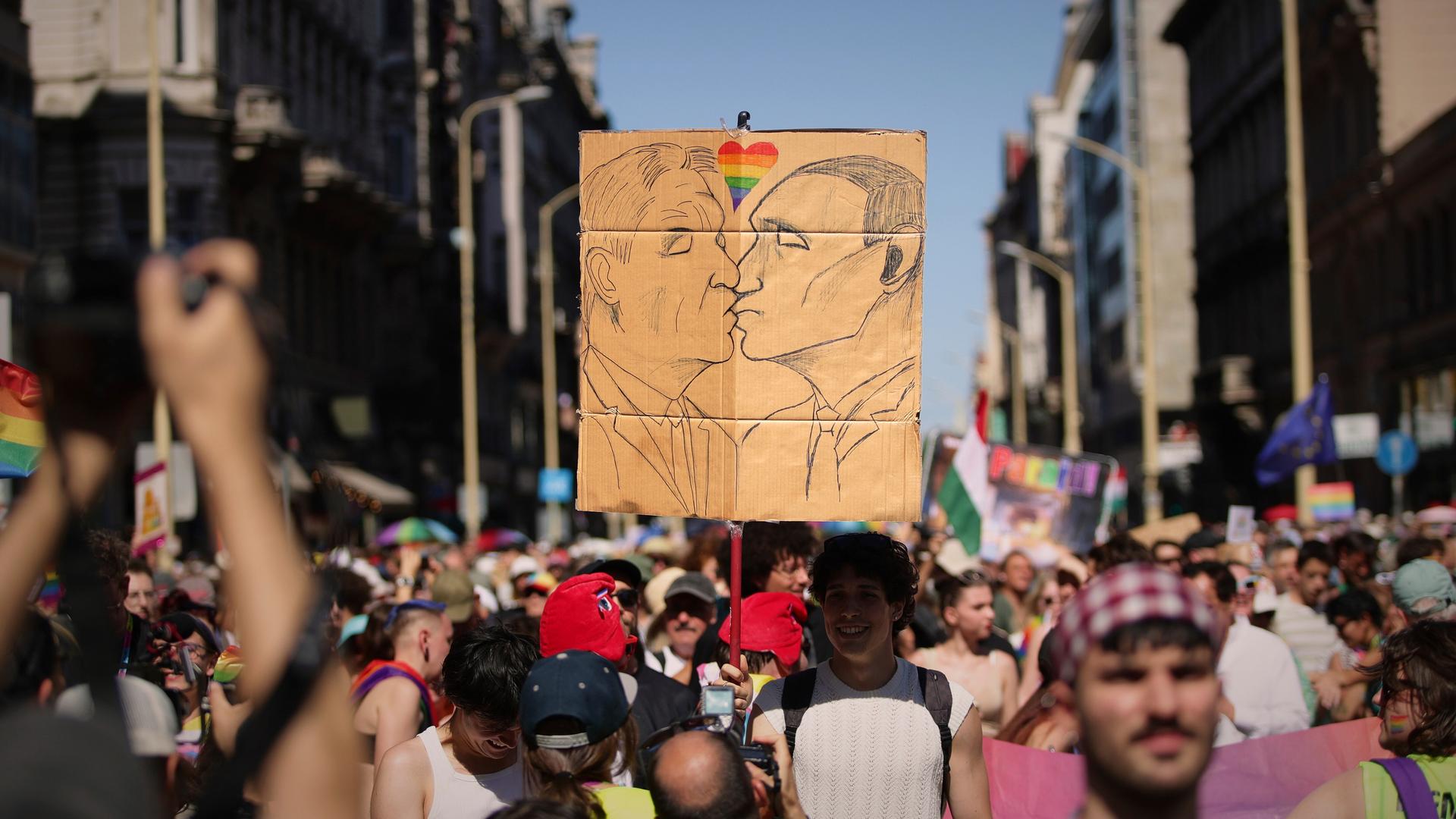 Menschen laufen durch das Zentrum von Budapest. Zu sehen ist eine Zeichnung auf einem Stück Pappe. Menschen laufen durch das Zentrum von Budapest. Zu sehen ist eine Zeichnung auf einem Stück Pappe.