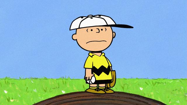 Die Zeichentrickfigur Charlie Brown steht einsam auf einer kleiner Erhebung und blickt ernüchtert um sich