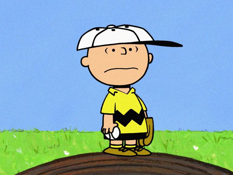 Die Zeichentrickfigur Charlie Brown steht einsam auf einer kleiner Erhebung und blickt ernüchtert um sich