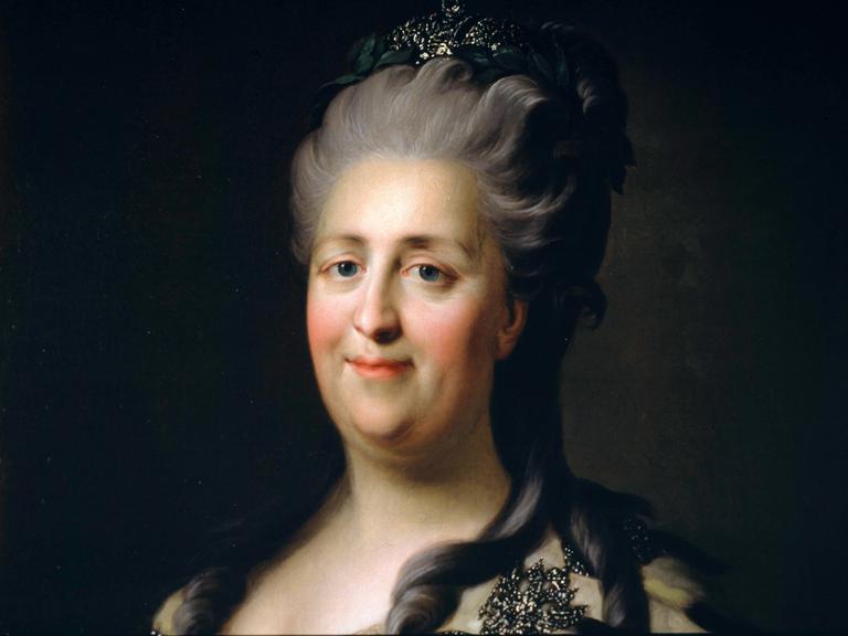 Eine Frau mit einem weichen Gesicht und insgesamt fließenden Gesichtszügen lächelt und blickt unmittelbar aus dem Bild heraus. Das Bild wirkt wie ein Herrscherporträt.