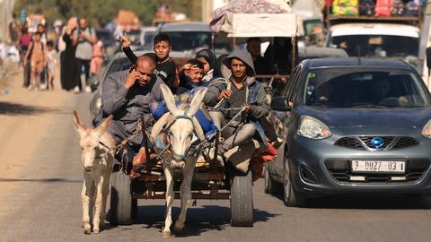 Das Foto zeigt eine Familie auf einem Eselkarren auf dem Weg vom Norden des Gazastreifens in den Süden.