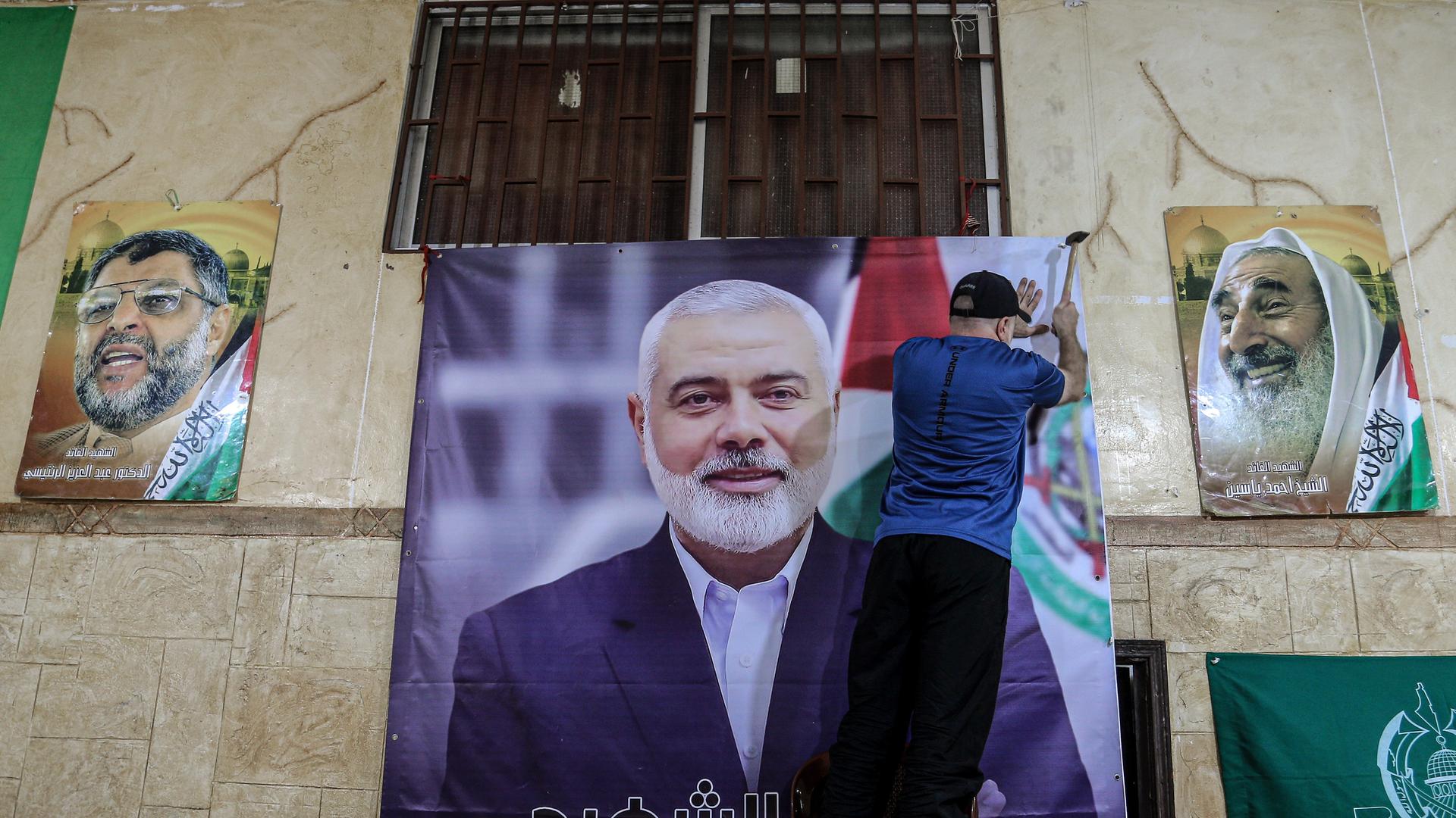 Ein Palästinenser hängt ein großes Foto des getöteten Hamas-Chefs Ismail Hanija im Flüchtlingslager Burj al-Brajneh auf.