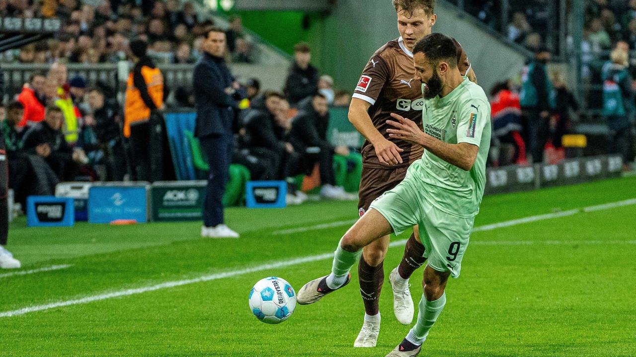 Die beiden Spieler, eng beeinander laufend, kämpfen um den Ball.