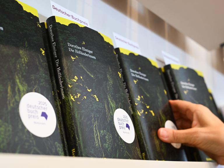 Eine Hand greift am Stand des Hanser Verlags auf der Frankfurter Buchmesse nach dem Buch der Schweizer Autorin Dorothee Elmiger mit dem Titel "Die Holländerinnen", dem Siegertitel beim Deutschen Buchpreis 2025. Eine Hand greift am Stand des Hanser Verlags auf der Frankfurter Buchmesse nach dem Buch der Schweizer Autorin Dorothee Elmiger mit dem Titel "Die Holländerinnen", dem Siegertitel beim Deutschen Buchpreis 2025.