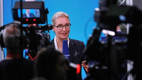 Die AfD-Co-Vorsitzende Alice Weidel steht vor zwei Kameras und spricht in ein Mikrofon während eines Interviews.