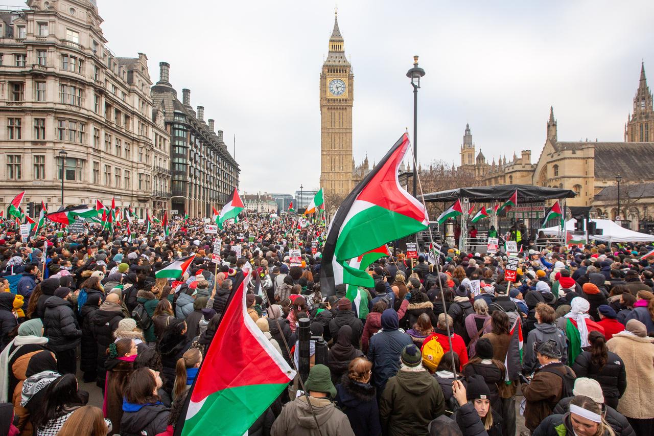 Demonstranten halten Fahnen während einer Demonstration zur Unterstützung der palästinensischen Bevölkerung. Im Hintergrund zeigt das Bild den Big Ben.