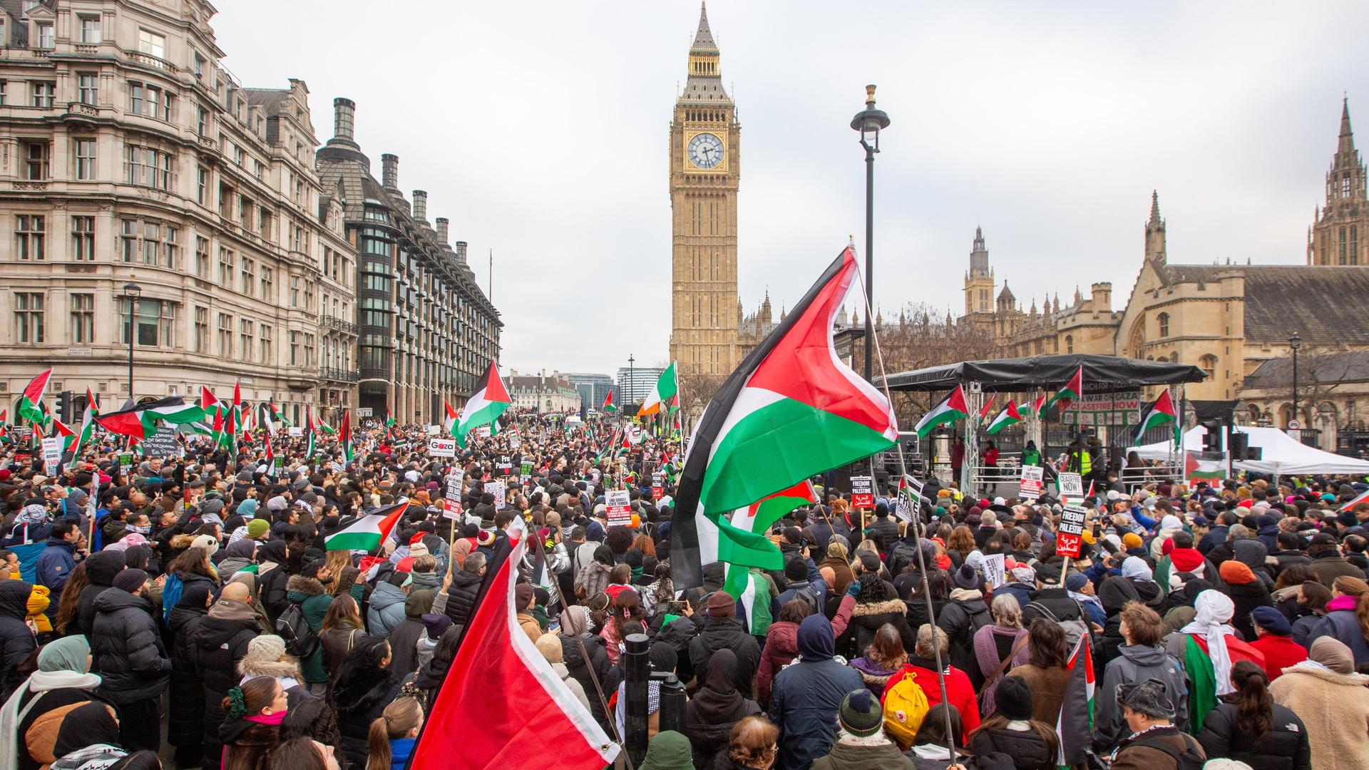 Demonstranten halten Fahnen während einer Demonstration zur Unterstützung der palästinensischen Bevölkerung. Im Hintergrund zeigt das Bild den Big Ben.