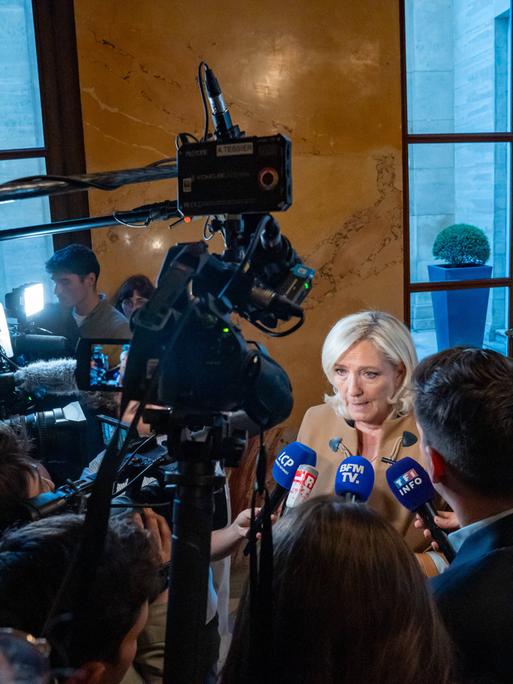 Marine Le Pen, die heutige Fraktionschefin des Rassemblement National (RN), wird von Journalisten und Kameras im Korridor der Nationalversammlung umringt. Paris, 20. Mai 2025