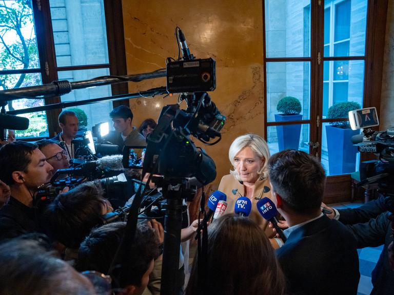 Marine Le Pen, die heutige Fraktionschefin des Rassemblement National (RN), wird von Journalisten und Kameras im Korridor der Nationalversammlung umringt. Paris, 20. Mai 2025