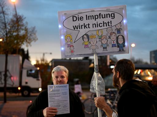 Querdenker-Demo im Münchner Hasenbergl, auf einem Schild ist eine Sprachblase an einem Kind zu sehen, darin steht: "Die Impfung wirkt nicht!"
