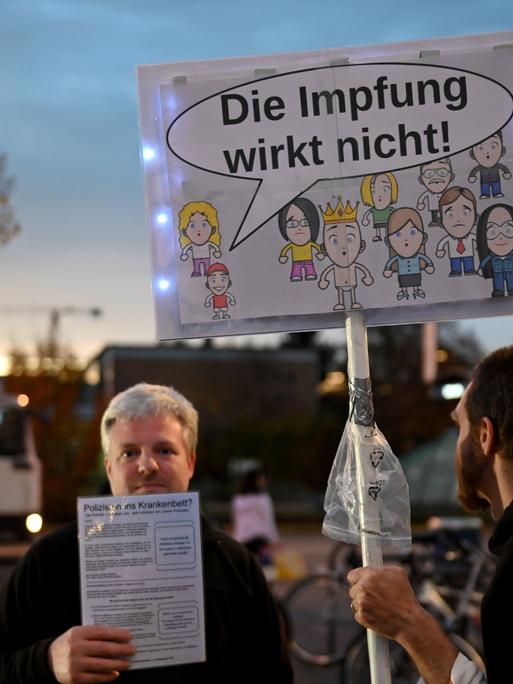 Querdenker-Demo im Münchner Hasenbergl, auf einem Schild ist eine Sprachblase an einem Kind zu sehen, darin steht: "Die Impfung wirkt nicht!"