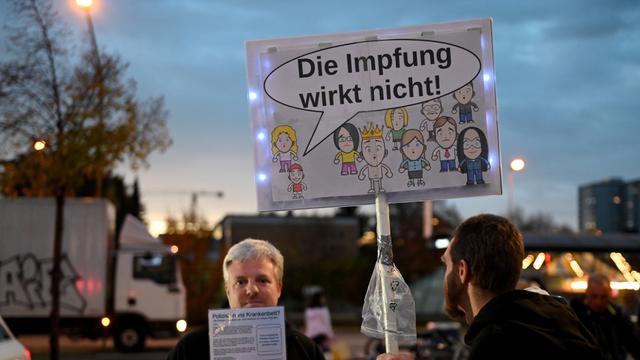Querdenker-Demo im Münchner Hasenbergl, auf einem Schild ist eine Sprachblase an einem Kind zu sehen, darin steht: "Die Impfung wirkt nicht!"