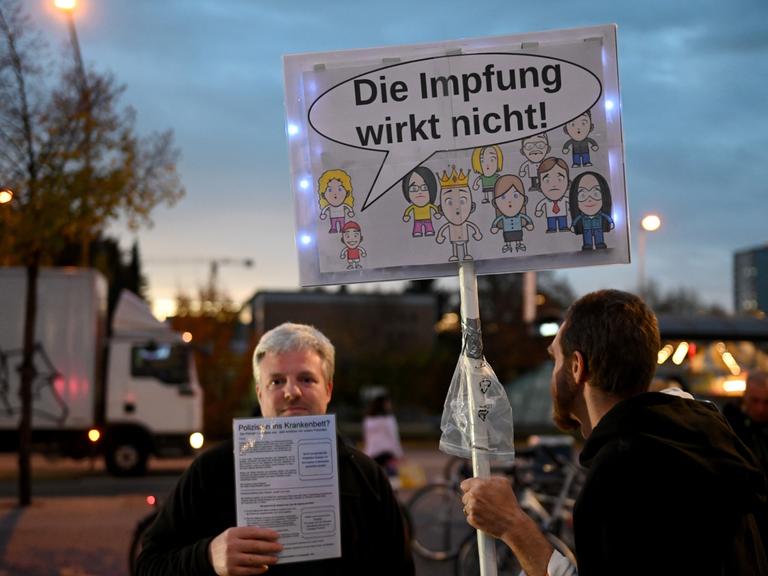 Querdenker-Demo im Münchner Hasenbergl, auf einem Schild ist eine Sprachblase an einem Kind zu sehen, darin steht: "Die Impfung wirkt nicht!"
