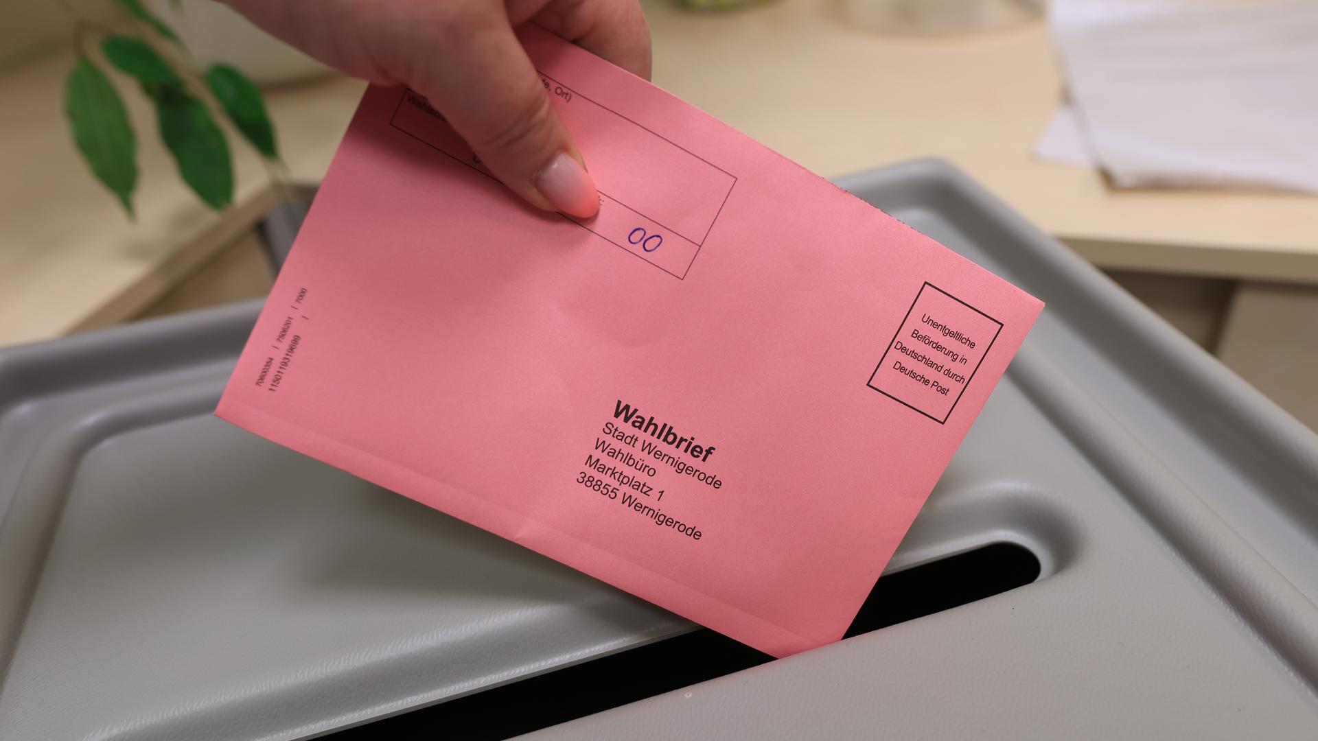 Eine Wählerin wirft zur Stimmabgabe einen Wahlbrief in einen Sammelbehälter. Für Briefwähler hat die Stadt Wernigerode ein Wahlbüro eingerichtet.