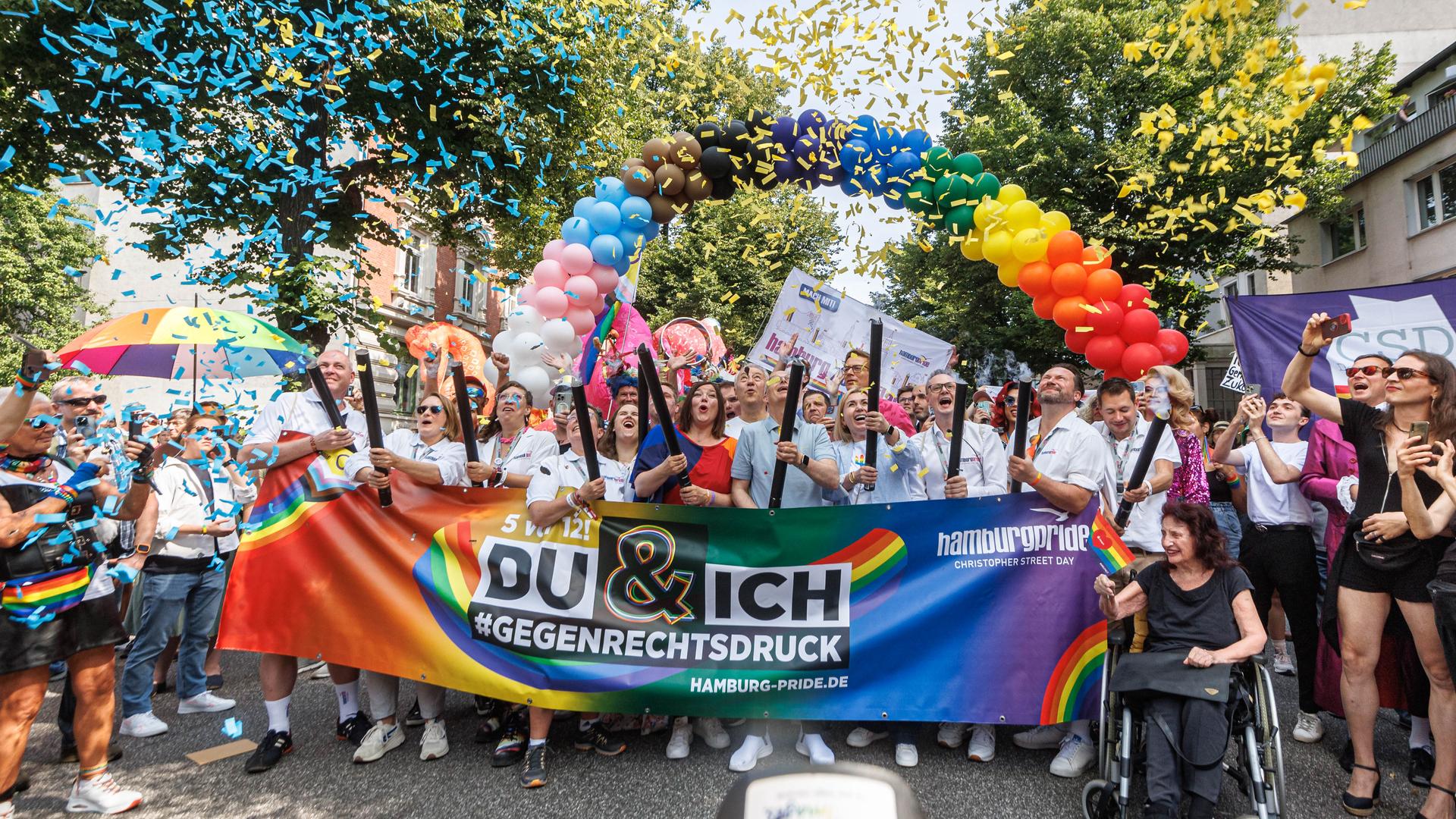 Unter einem Bogen von Luftballons, die einen Regenbogen formen stehen Demonstranten hinter einem Banner mit der Aufschrift: "Du & ich gegen Rechtsdruck"