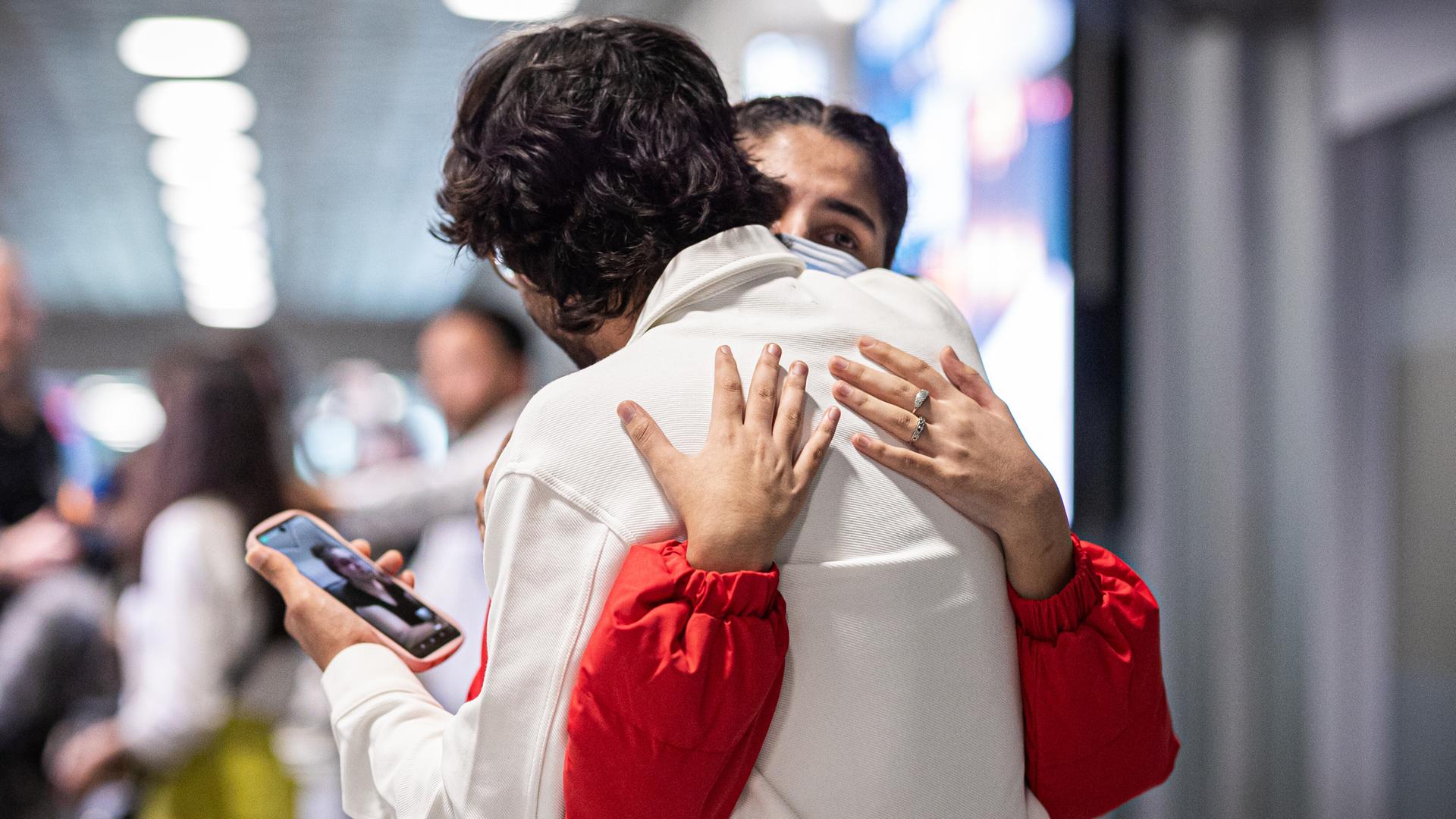 Menschen aus Afghanistan, die zuvor auf dem Flughafen Hannover gelandet sind, umarmen sich