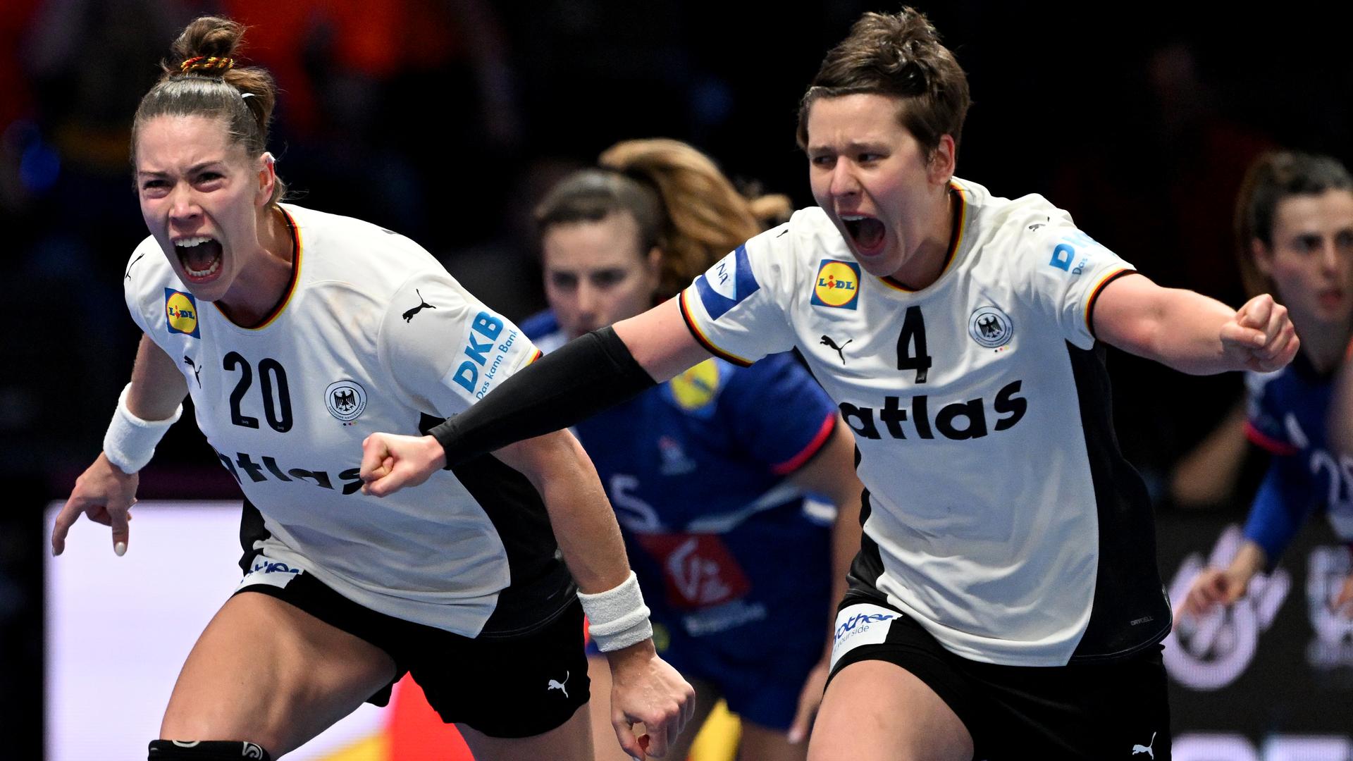 Die deutschen Handballerinnen Emily Vogel und Alina Grijseels rennen jubelnd und vor Glück schreiend über das Spielfeld.