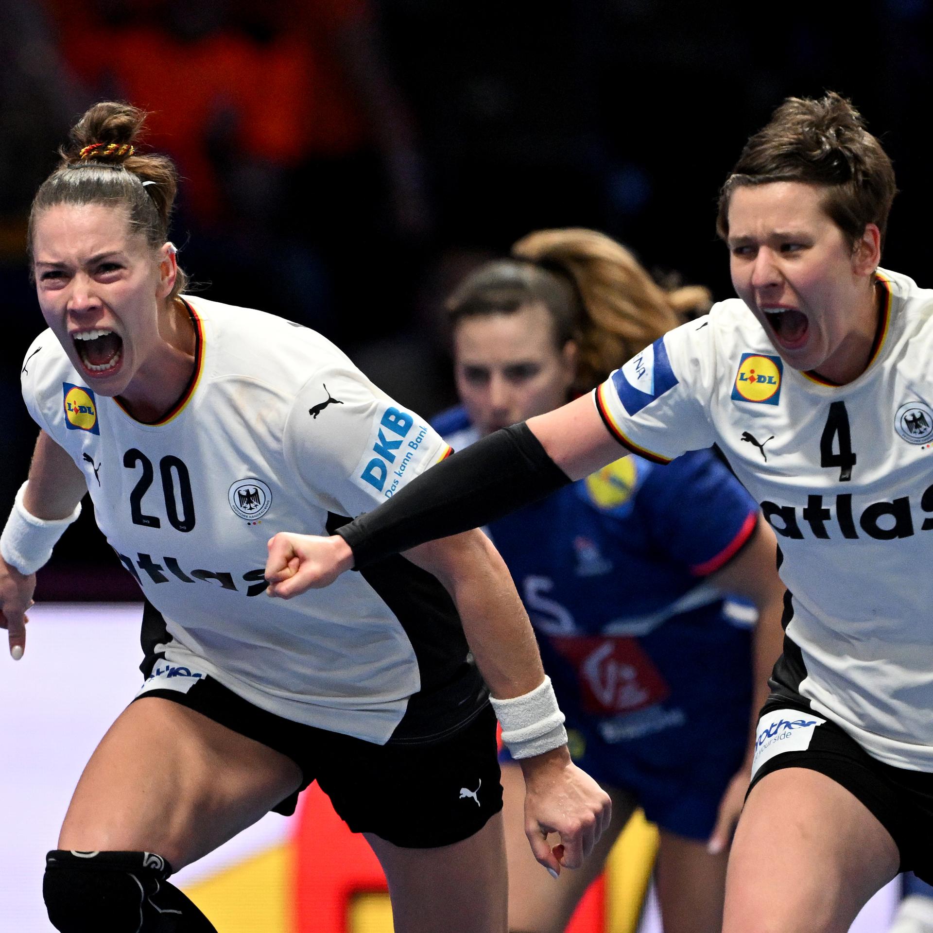 Die deutschen Handballerinnen Emily Vogel und Alina Grijseels rennen jubelnd und vor Glück schreiend über das Spielfeld.