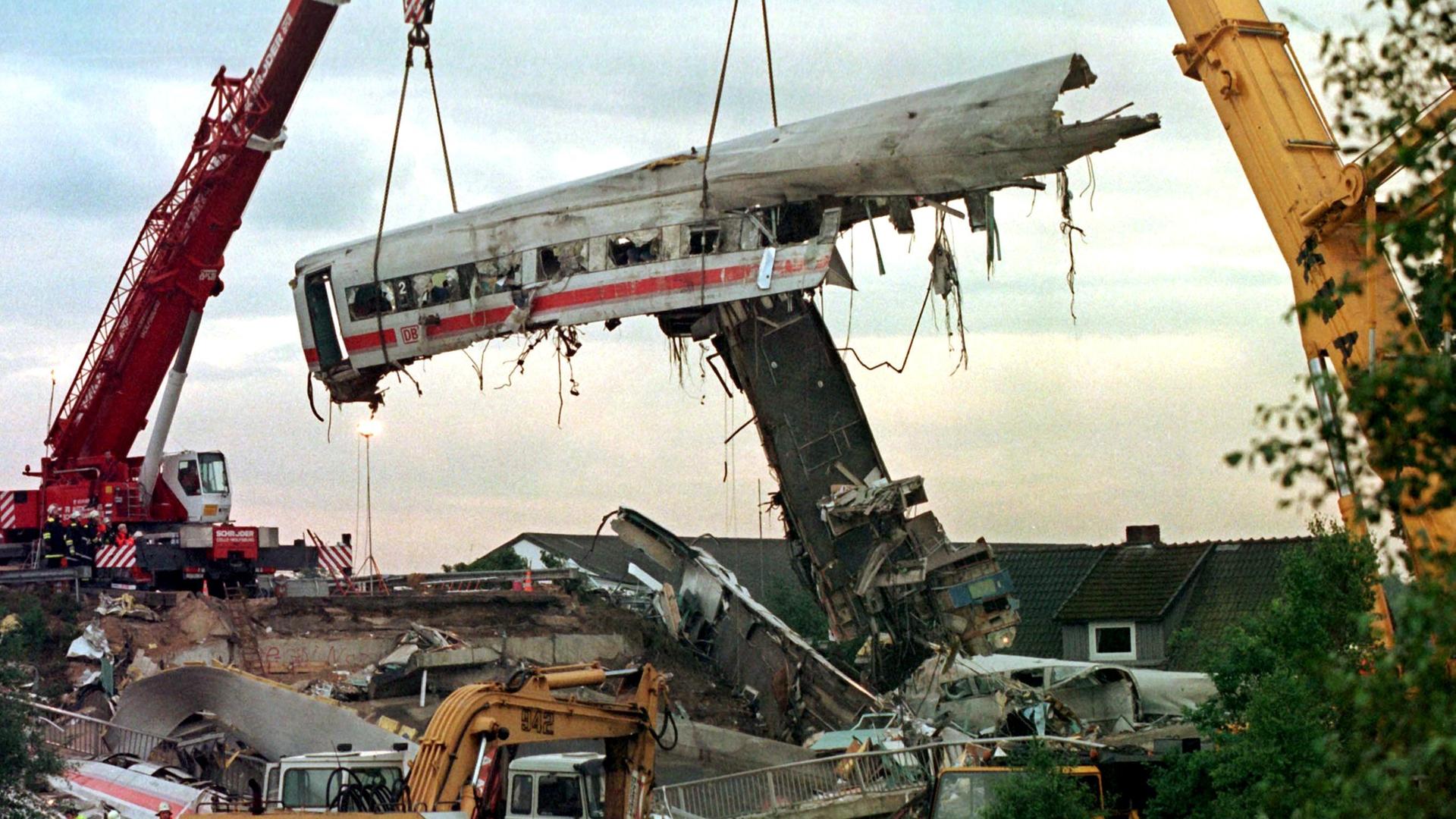 Zwei große Kräne heben am 4.6.1998 in Eschede einen der vier verkeilten Wagen des verunglückten ICE in die Höhe. 