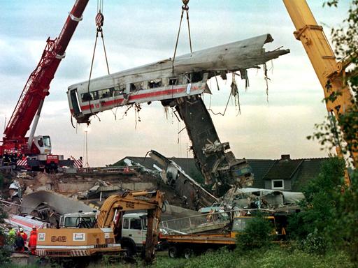 Zwei große Kräne heben am 4.6.1998 in Eschede einen der vier verkeilten Wagen des verunglückten ICE in die Höhe. 