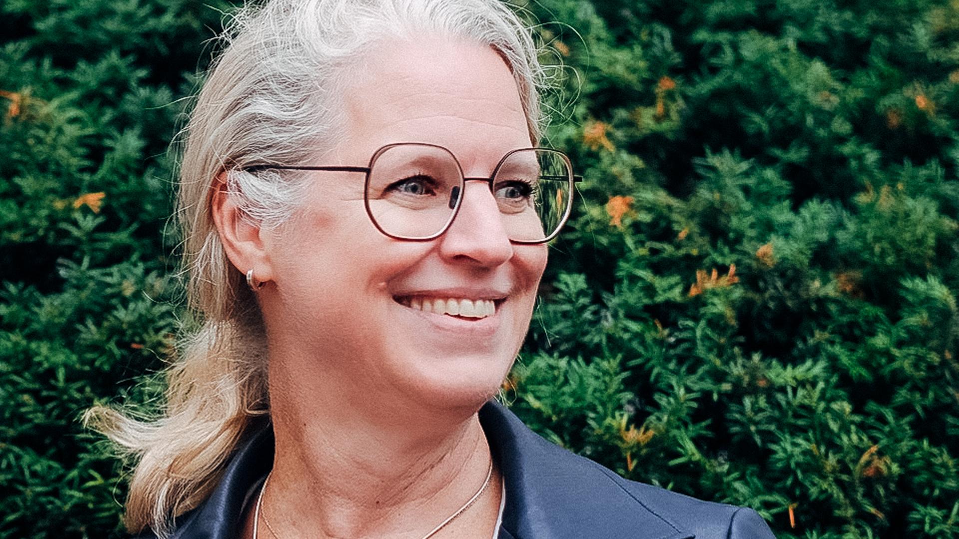 Isabel Bogdan vor einer grünen Hecke