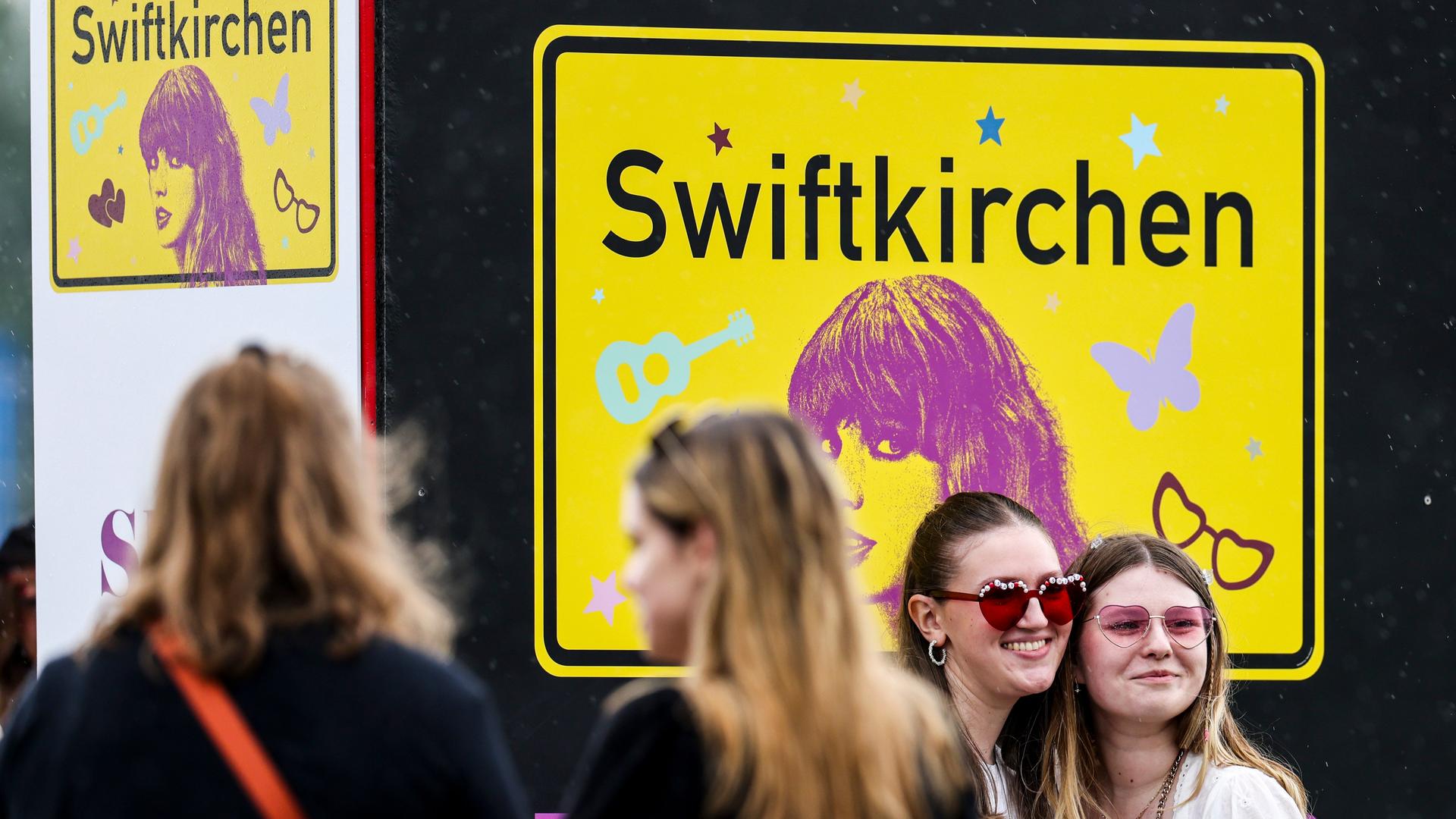Fans lassen sich vor dem Swiftkirchen-Schild fotografieren. Im Rahmen der Eras-Tour tritt Swift in Deutschland unter anderem in Hamburg und München auf.