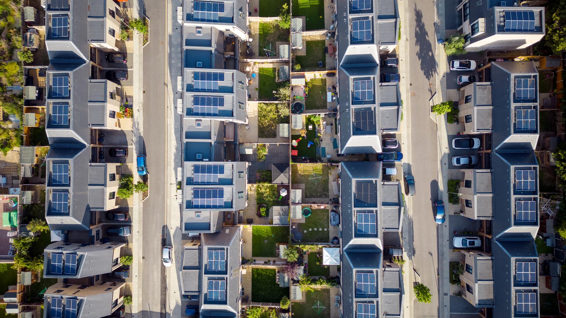 Luftansicht eines modernen Wohnblocks mit Solaranlagen auf den Dächern.