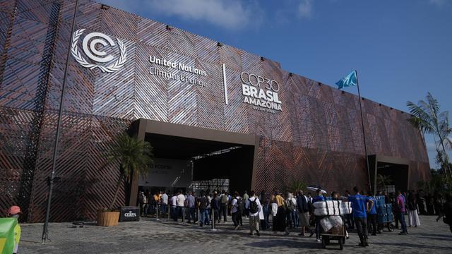 Teilnehmerinnen und Teilnehmer warten vor dem Eingang von der Welt-Klima-Konferenz.