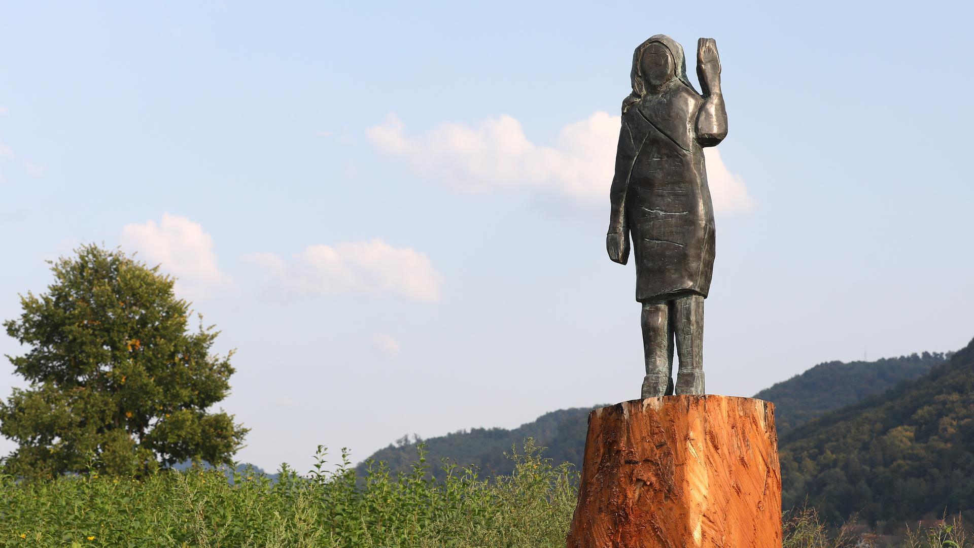 Die Bronze-Statue von Melania Trump in Slowenien. Sie steht auf einem Baumstumpf auf einer Wiese. Die Bronze-Statue von Melania Trump in Slowenien. Sie steht auf einem Baumstumpf auf einer Wiese.