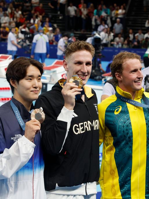 Schwimmer Lukas Märtens (Mitte) holt Gold für Deutschland, Silber geht an Elijah Winnington (Australien, rechts), Bronze holt der Südkoreaner Kim Woomin (links).