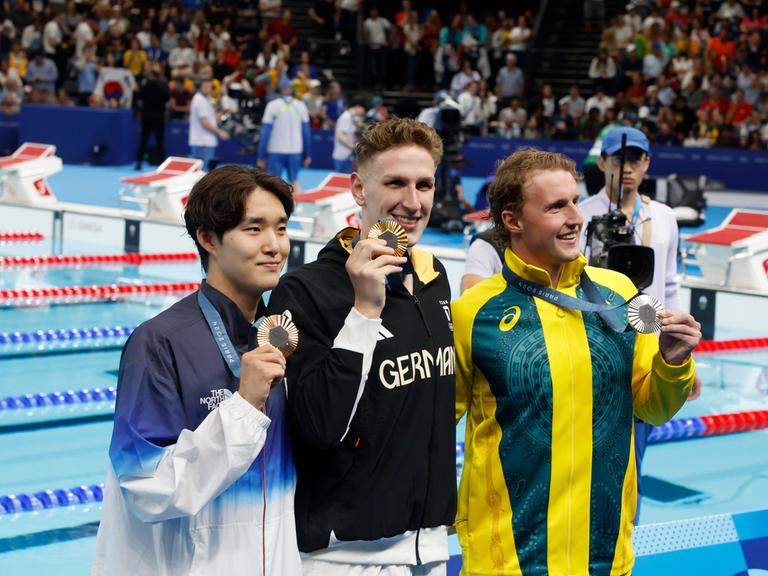 Schwimmer Lukas Märtens (Mitte) holt Gold für Deutschland, Silber geht an Elijah Winnington (Australien, rechts), Bronze holt der Südkoreaner Kim Woomin (links).