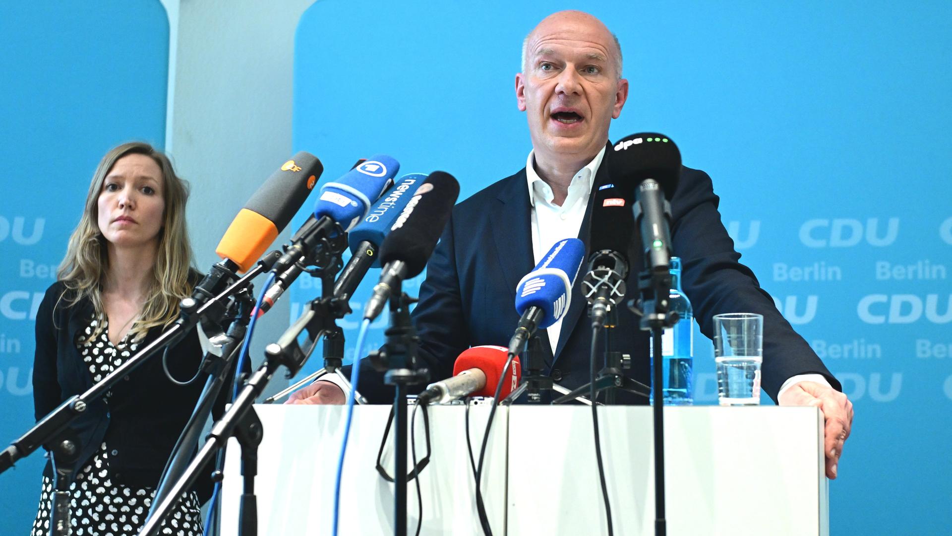 Kai Wegner steht während eines Pressetermins an einem Pult und spricht in zahlreiche Mikrofone. Im Hintergrund ist eine blaue Wand mit weißen CDU-Logos zu sehen. Kai Wegner steht während eines Pressetermins an einem Pult und spricht in zahlreiche Mikrofone. Im Hintergrund ist eine blaue Wand mit weißen CDU-Logos zu sehen.