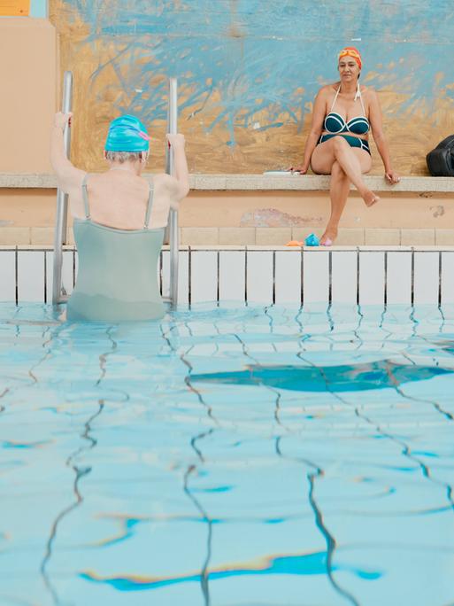 Frauen nach Wassergymnastik und Schwimmen bei Aussteigen aus deinem Schwimmbecken in einer Schwimmhalle.