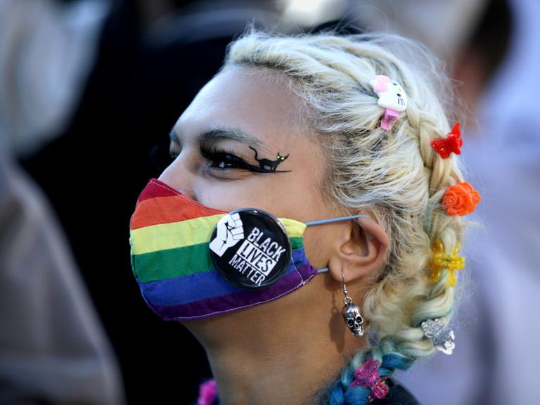 BOSTON, MA - OCTOBER 17: A protester wearing a rainbow mask and a Black Lives Matter pin joins roughly 1,000 demonstrators as they take over the streets around Boston Common in a show of resistance to President Trump in Boston on Oct. 17, 2020. The demonstrations were planned by the Womens March organization that staged marches around the world the day after Trumps inauguration to protest the confirmation of Supreme Court nominee Amy Coney Barrett and to rally voter opposition to Trumps reelection. (Photo by Jonathan Wiggs/The Boston Globe via Getty Images)