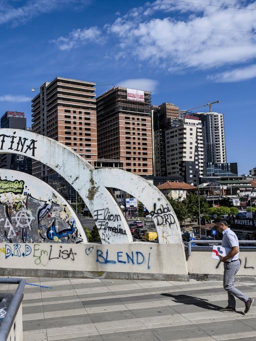 Ein Mann läuft am "Pristina" Graffiti inmitten der kosovarischen Hauptstadt vorbei 