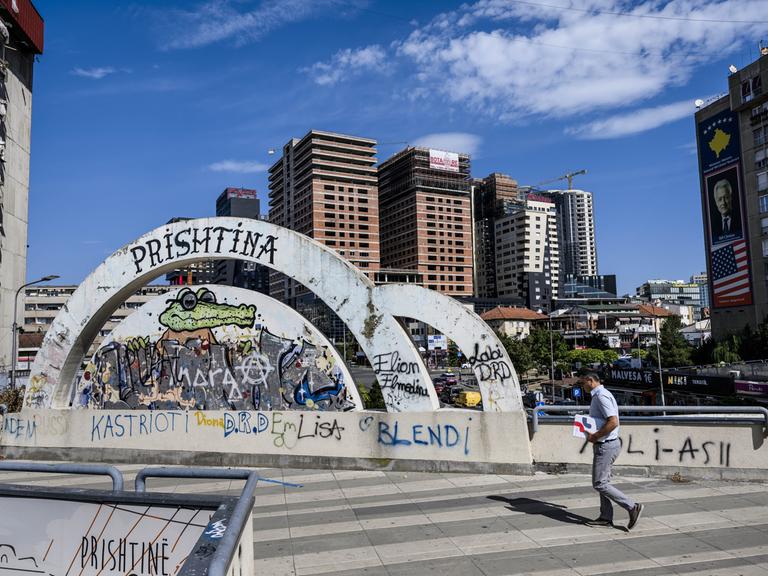 Ein Mann läuft am "Pristina" Graffiti inmitten der kosovarischen Hauptstadt vorbei 